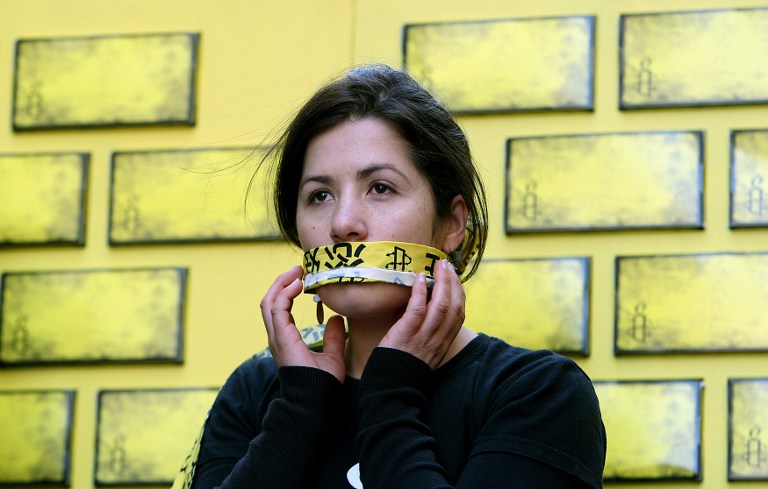An Amnesty International member covers her mouth during an event in Sydney on July 30, 2008 as part of a campaign to end internet censorship in China. Photo: AFP/Greg Wood.